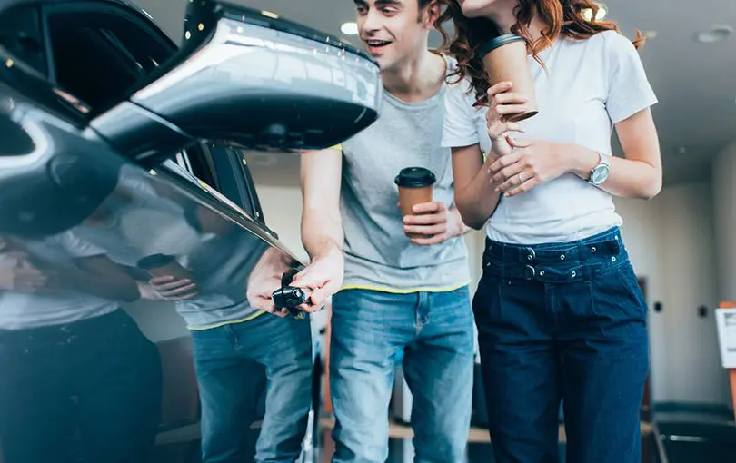 Man and woman checking car at dealer | CarMoney.co.uk