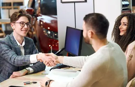 Man and women making a deal at dealer | CarMoney.co.uk